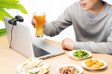 自宅でオンライン飲み会をしている男性