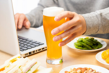 自宅でオンライン飲み会をしている男性