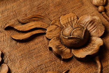 Wood carving. Woodworking. Ancient pattern of flowers and leaves carved on a wooden background close up macro