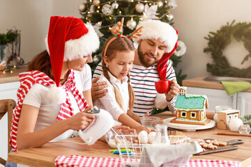 Happy family making tasty gingerbread cookies in kitchen on Christmas eve