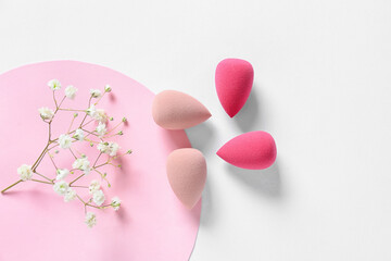 Composition with makeup sponges on white background