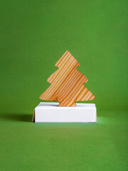 The zero waste new year concept as a wooden fir tree on the green background.