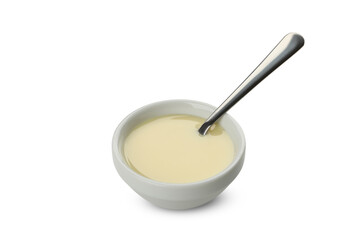 Bowl with condensed milk and spoon isolated on white background
