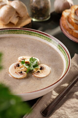 Cream soup with champignons and croutons on the table. Still life
