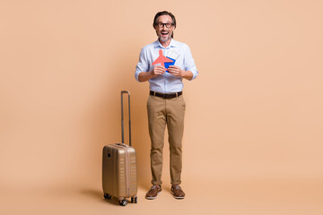 Full length photo of guy luggage hold paper plane tickets passport wear specs shirt pants shoes...