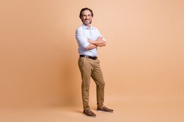 Full length photo of man crossed arms toothy smile wear specs shirt trousers shoes isolated beige...