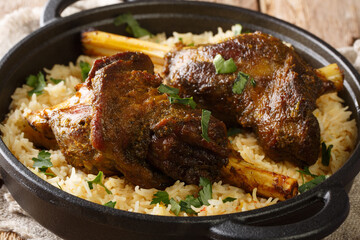 Haneeth is a slow roasted lamb dish from Yemen served on a plate of rice closeup on the table. horizontal