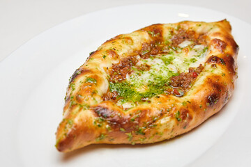 Khachapuri meat on a white plate. Close-up, selective focus