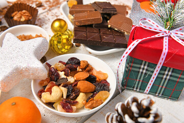 sweet food top view background for merry christmas or new year holiday decoration - chocolate candies, tangerines, cookies on white wood
