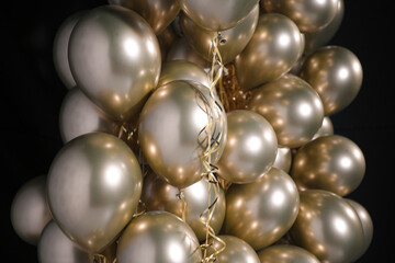 Celebration and party golden christmas baloons with golden ribbons isolated on black background. Event decoration. New year eve. Christmas party.