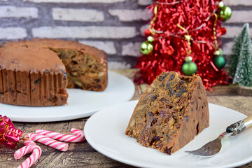 Fototapeta na wymiar Traditional Christmas Cake with Dried Fruits and Nuts. Christmas Decoration at the Background