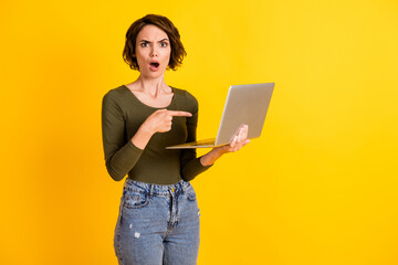 Photo of astonished lady point index finger laptop shout wear jumper isolated over bright yellow color background