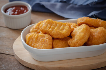 Fried crispy chicken nuggets and ketchup sauce in bowl