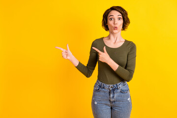 Photo of astonished girl point finger empty space for sale adverts promotion isolated on bright yellow color background