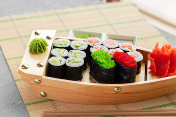 Set of maki sushi on wooden boat tray