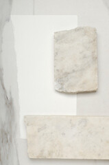 Two white pieces of marble, white ripped paper on the marble desk.Empty space for design or product