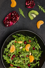Fruit salad with arugula, tangerines and pomegranate seeds