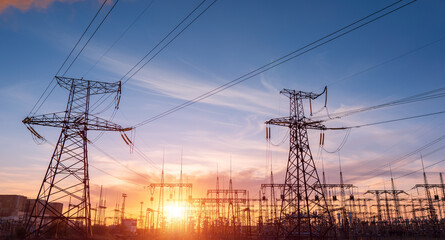 High-voltage power lines at sunset or sunrise. High voltage electric transmission tower © yelantsevv