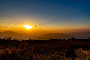 秋の阿蘇草千里展望所からの眺める外輪山の夕陽