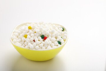 Indian festival makar sankranti concept : Tilgul in bowl with copy space on white background