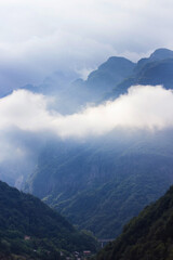 Naklejka premium Beautiful Alpine mountainous scenery on the road to the city of Siena, Tuscany, Italy. Alps mountains on cloudy and foggy day. Soft selective focus, long exposure
