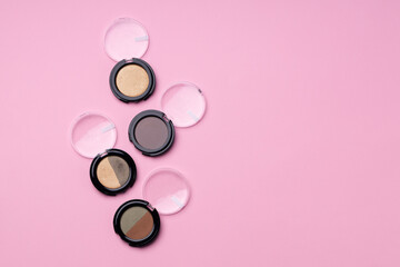 Set of eyeshadows make up products on pink