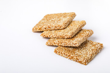 Til chikki and sesame seed ball on white background is an Indian sweet dish made with jaggery and sesame seeds.