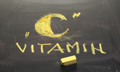 Vitamin C written on black chalkboard with yellow chalk, blackboard texture and background