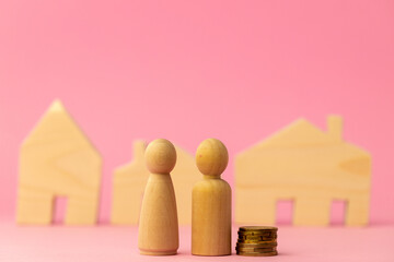 Wooden house miniature and toy people on pink background