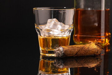 Glass of whisky and lighted cigar on black background