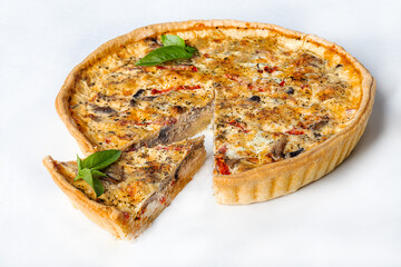 Quiche stuffed with mushrooms, chicken and tomato from shortcrust pastry on a light background. Home delivery. Festive concept. Quarantine.