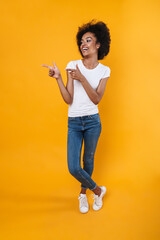 Joyful african american girl laughing and pointing finger at copyspace