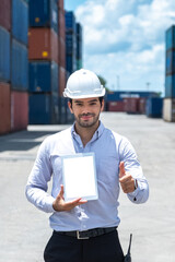 Close up Caucasian engineer or Shipping officer holding blank screen tablet and doing thumbs up in containers shipyard with clipping path on tablet screen. Business Cargo.