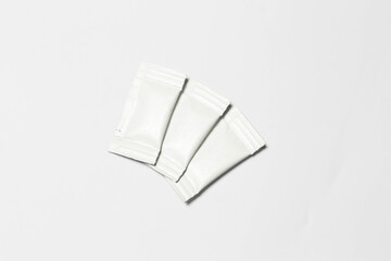 Close-up composition of white sachets on a white background.