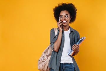 Joyful african american girl smiling and talking on cellphone