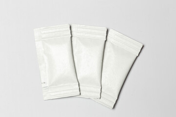 Close-up composition of white sachets on a white background.