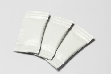 Close-up composition of white sachets on a white background.