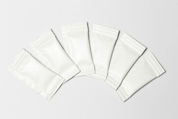 Close-up composition of white sachets on a white background.