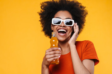Joyful african american girl in sunglasses drinking soda and laughing - obrazy, fototapety, plakaty