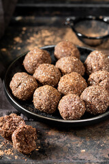 Chocolate coconuts. Chocolate balls with coconut. Chocolate candies or cookies with coconut, cinnamon and powdered sugar