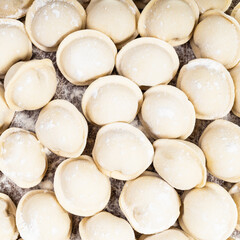 top view of frozen Pelmeni (russian dumplings filled with minced meat) close up on wooden board