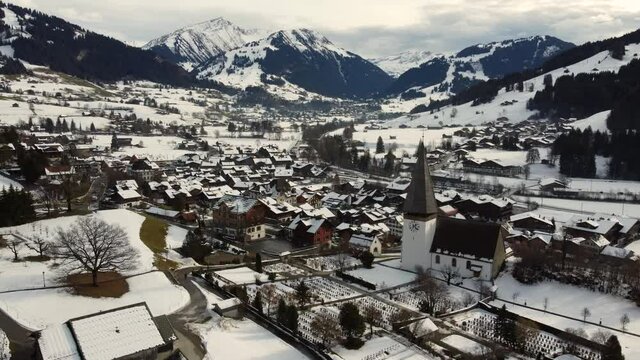 The snow-capped village of Saanen with its church, right next to Gstaad, Switzerland. 