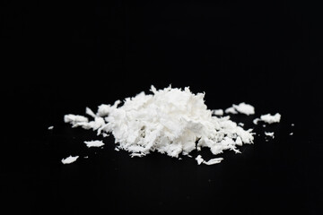 Obraz na płótnie Canvas a pile of poured white artificial synthetic snow on a black background