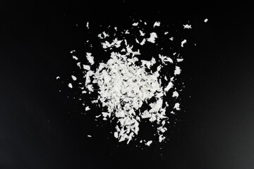 Obraz premium a pile of poured white artificial synthetic snow on a black background