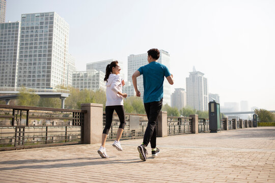 Happy young couple running in park