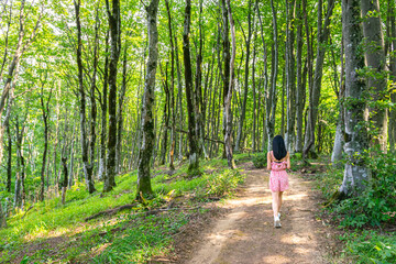 Young attractive woman walks on the path in Sataplia nature reserve. Tourist attractions in Georgia