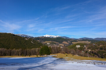 meadow with snow and beautiful landscape with mountains while hiking