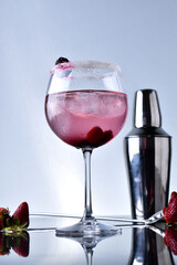 drinks in glass and glass with lemon, red berries and strawberries with shaker in elegant background