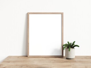 Single blank rectangular picture frame with thin wooden border standing on wooden surface leaning on white wall. 3D Illustration.