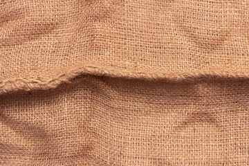 The texture of an uneven crumpled, roughly woven burlap.